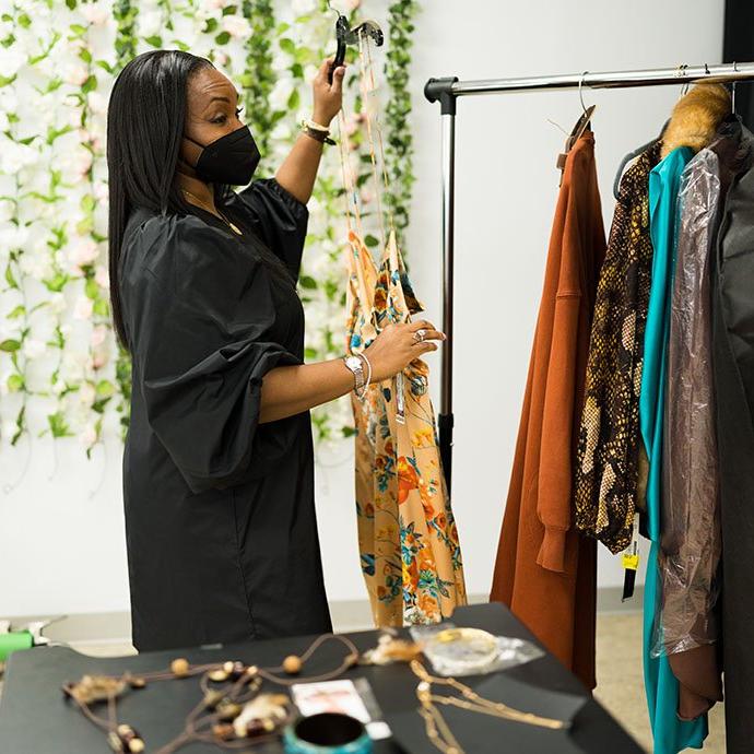 Woman putting clothes on garment rack